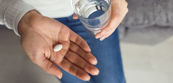 Woman preparing to swallow a pill