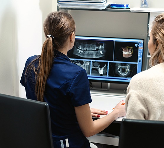 Dental team members looking at digital x-rays