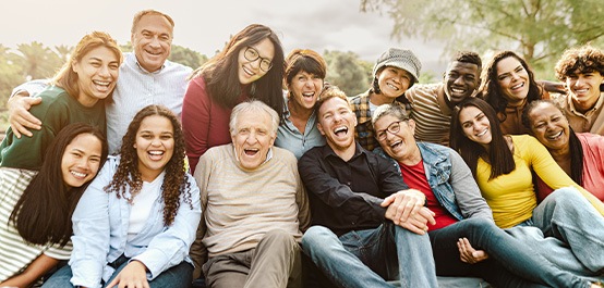 Group of people outside huddled together smiling