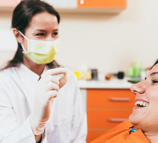 Dentist showing patient extracted tooth in Owasso