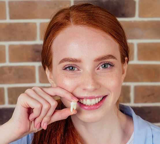 Patient holding up their extracted tooth in Owasso