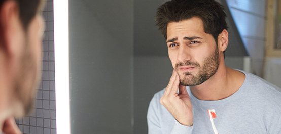 Man with toothache holding jaw