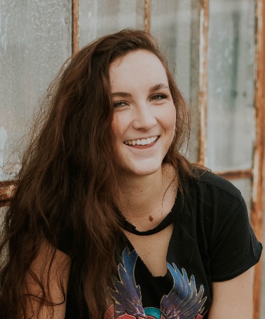 Young woman in black shirt smiling outdoors