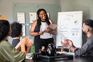 Woman smiling while giving presentation at work