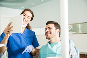 Dentist showing patient image on tablet