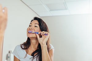 Woman brushing her teeth in bathroom
