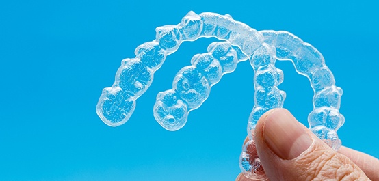 patient holding two Invisalign aligners