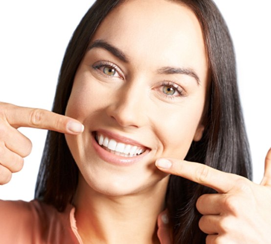 Smiling woman pointing to her teeth