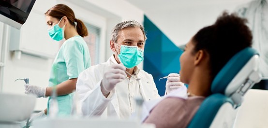 Owasso emergency dentist smiling at patient during exam