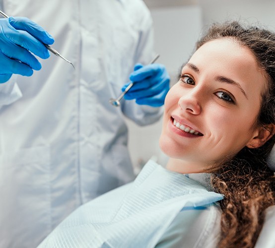 patient smiling while sitting in dental chair 