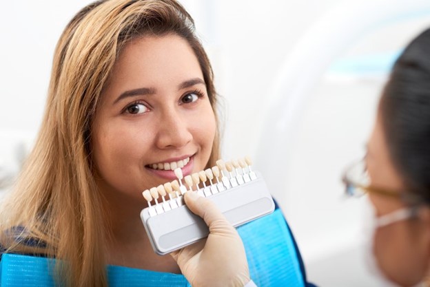 Woman at dentist looking at row of veneers.