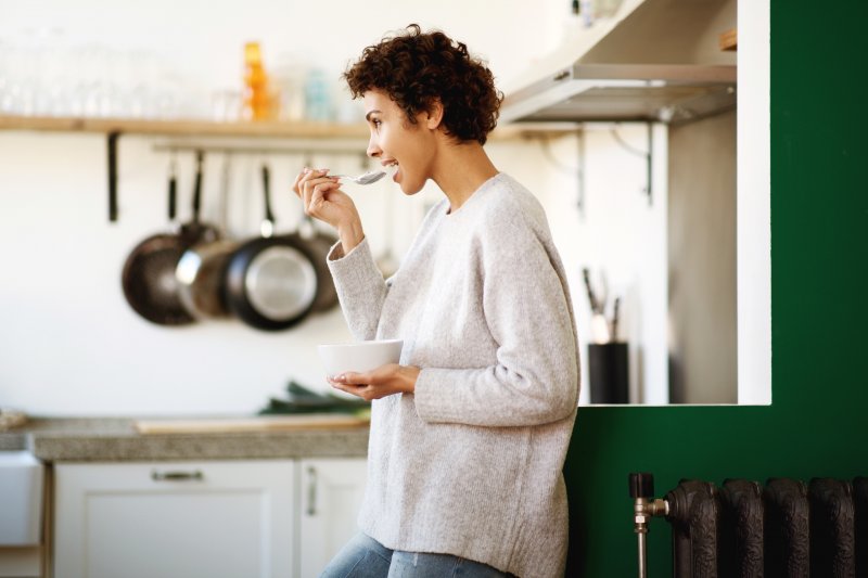 young woman eating in kitchen